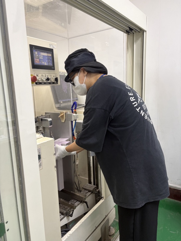 實習生操作品檢機台，檢測印刷完成的包裝