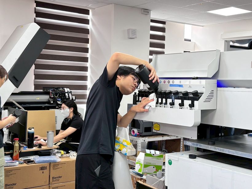 實習生為印刷設備補充墨水