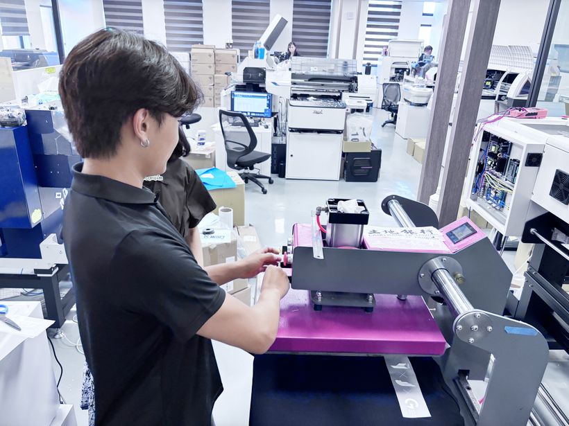 實習生操作燙印機，完成服飾圖樣轉印