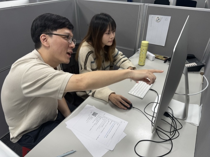 業師在電腦前為實習生進行設計指導